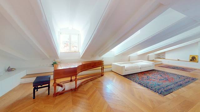 Das Wohnzimmer mit Klavier unter der Dachschräge